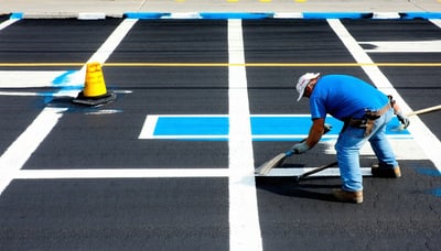 Pavement marking professionals painting crisp lines on a parking lot Pavement marking professionals painting crisp lines on a parking lot